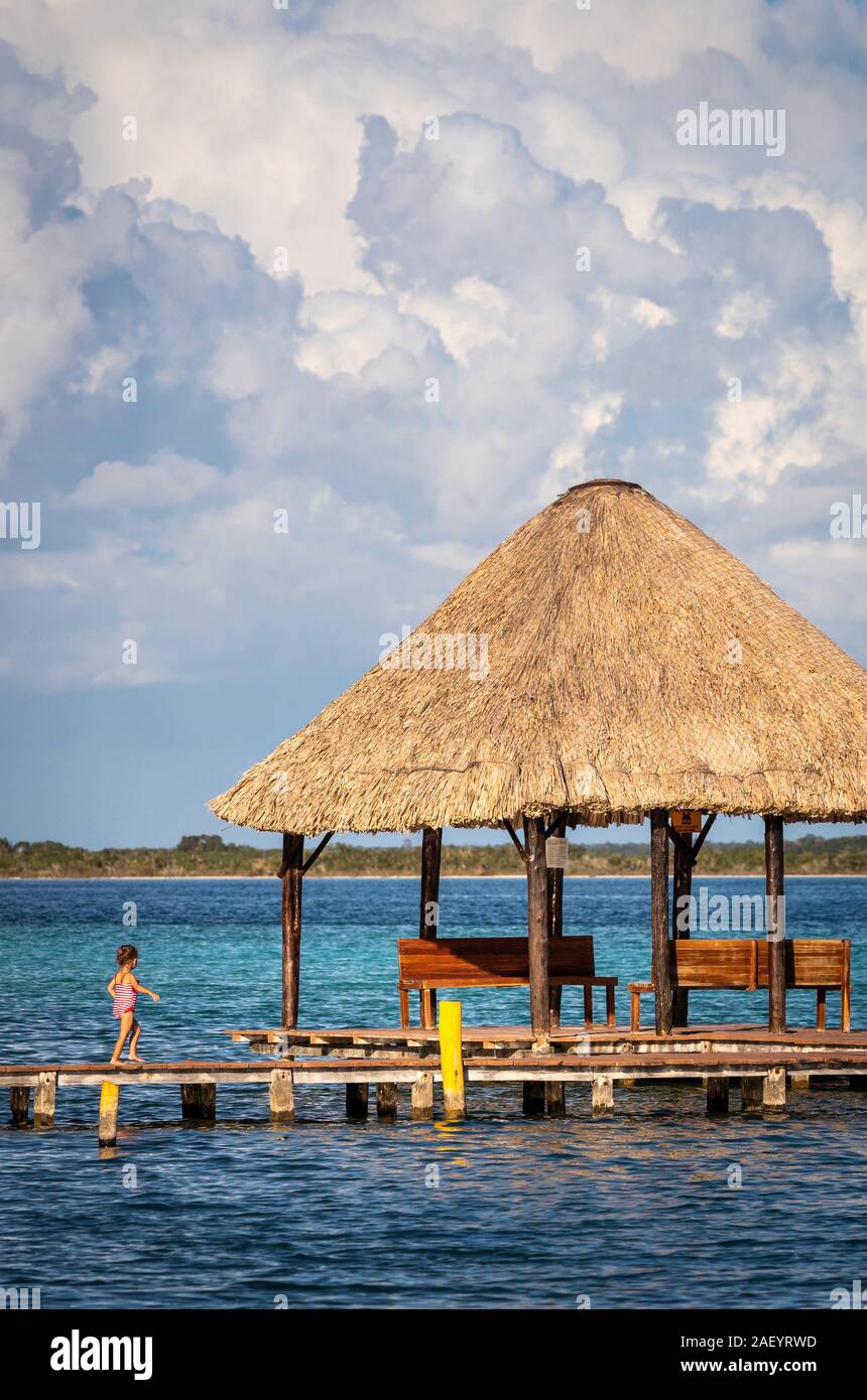 Ein kleines Mädchen geht auf den Docks in Bacalar, Quintana Roo, Mexiko. Stockfoto