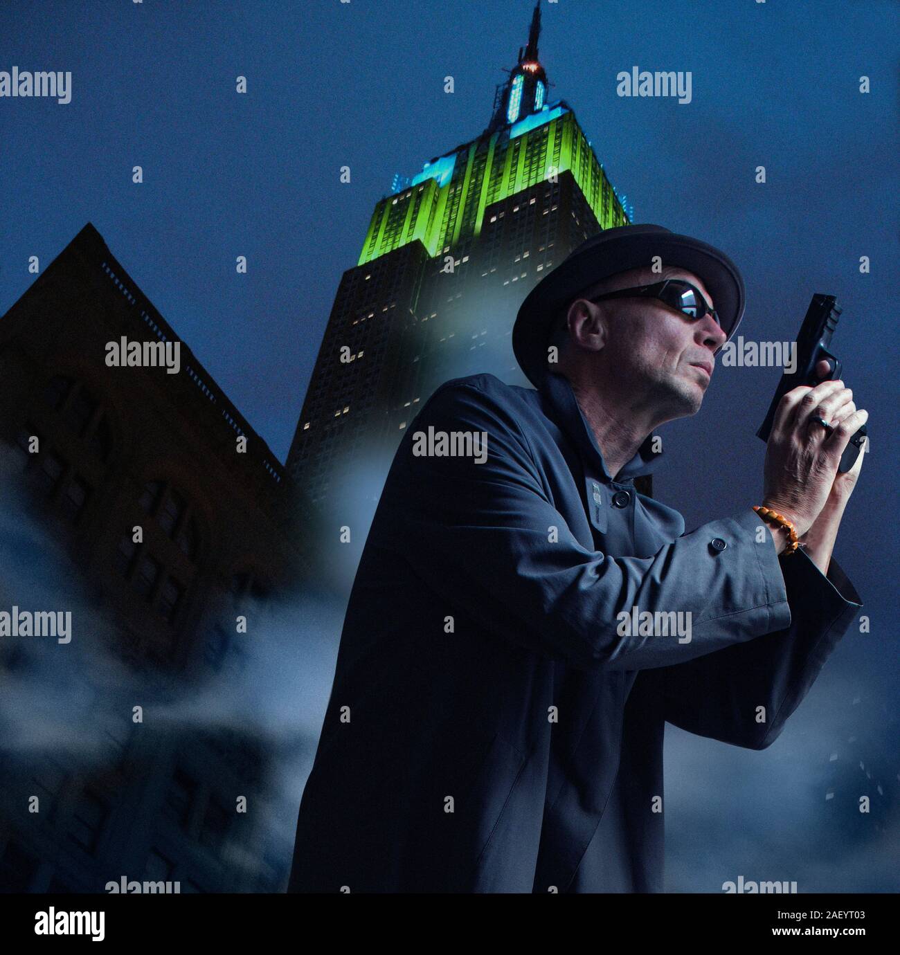 Low Angle View der geheimnisvolle Mann mit Pistole gegen Empire State Building Stockfoto