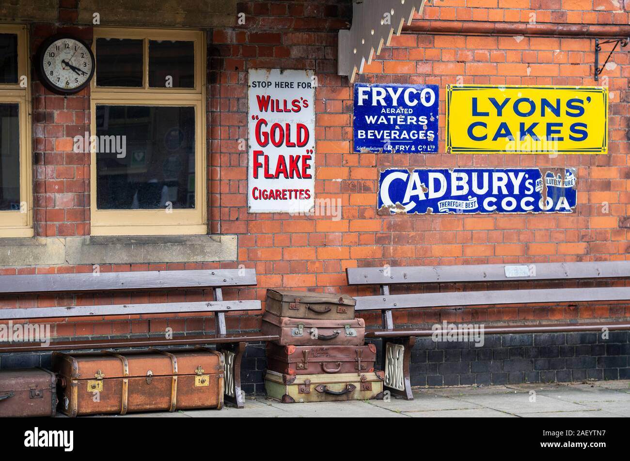Alte Werbeschilder auf einer Plattform an das Erbe Bahnhof in Toddington, Gloucestershire, England, Großbritannien Stockfoto