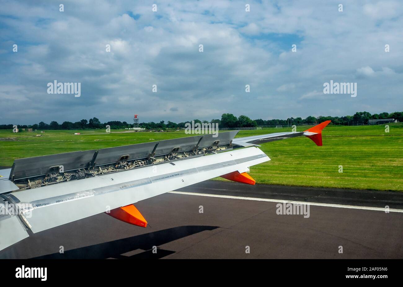 Flugzeugflügel mit erweiterter Klappen und Spoiler bei der Landung auf der Landebahn am Flughafen Stockfoto