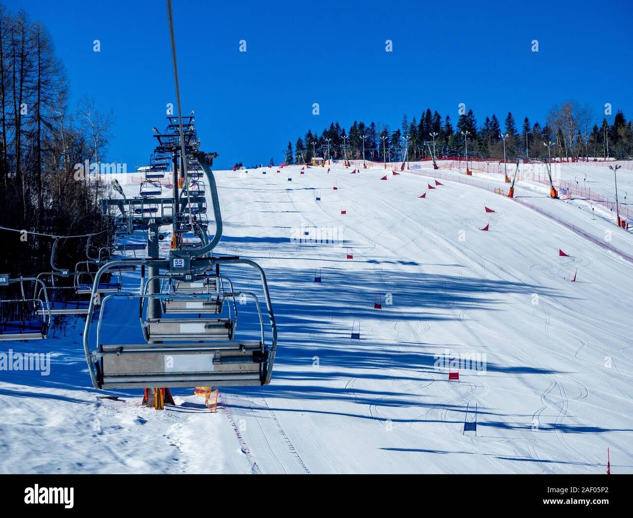 Ski liftes (Sesselbahn und Skilift) und Skipiste mit Slalom Tore für Skifahrer und Snowboarder im Bialka ski resort in Polen Stockfoto