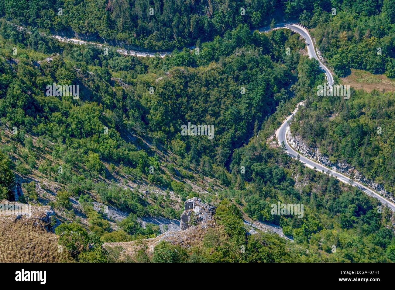 Eine kurvenreiche Bergstraße durch den Wald in extremen Höhen. Stockfoto