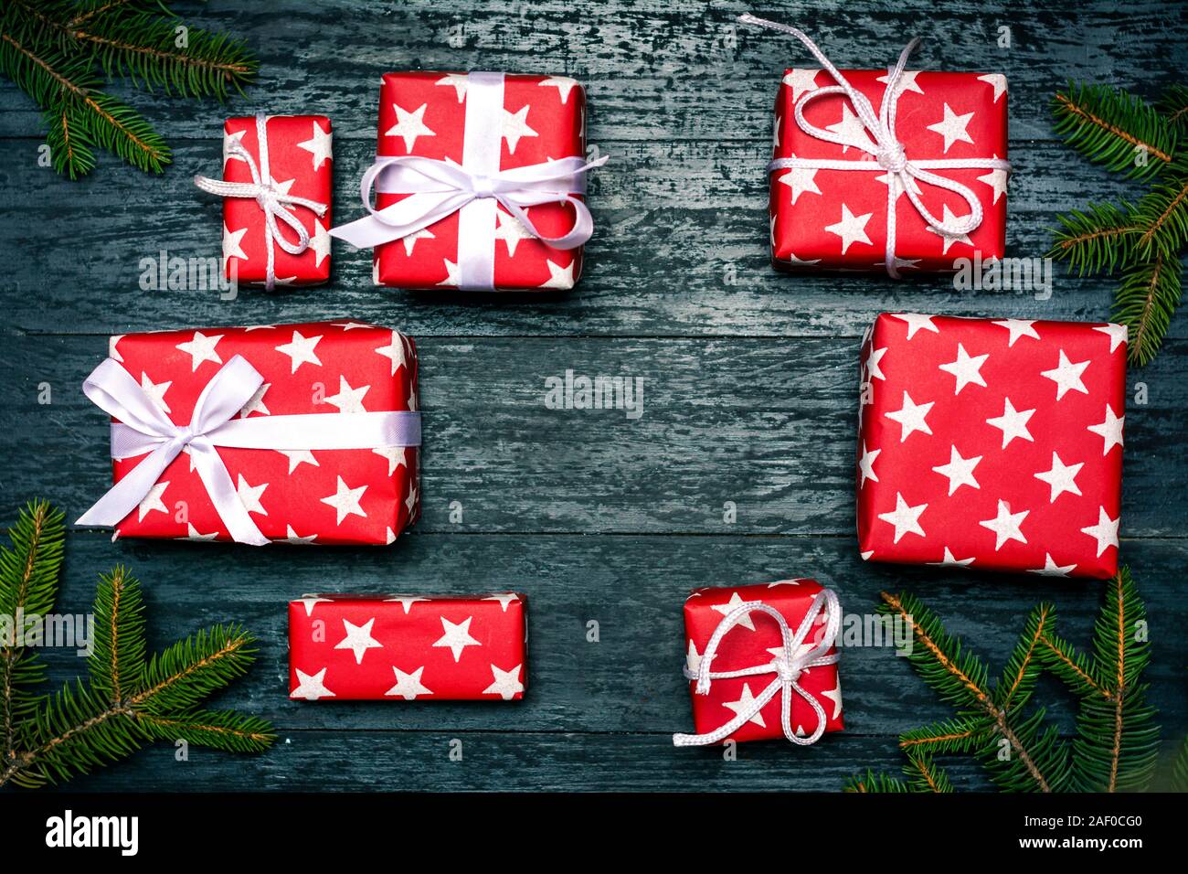 Weihnachtsgeschenke auf einem dunklen Holztisch, oben flach Stockfoto