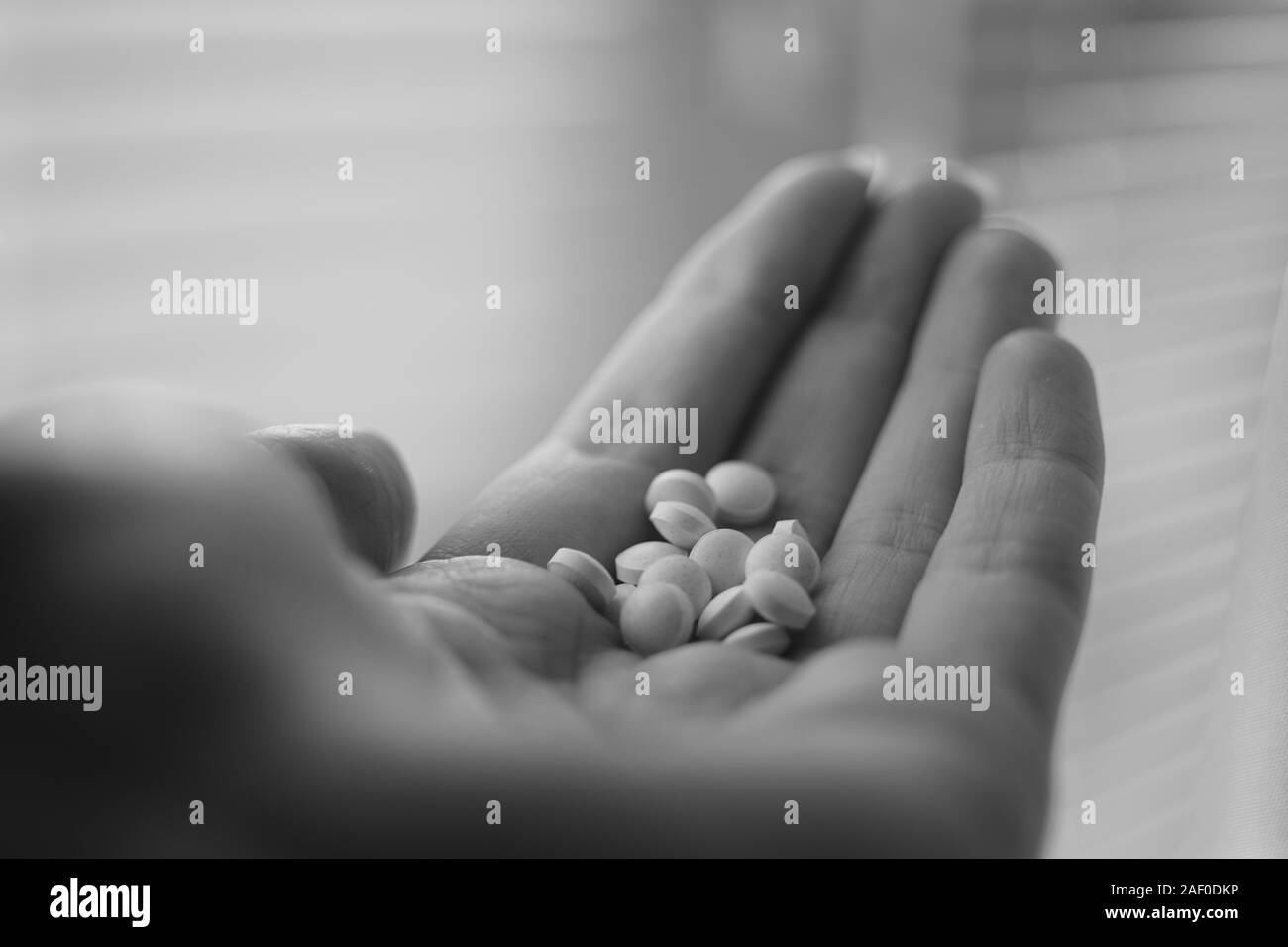 Medizinische Pillen in der menschlichen Hand Nahaufnahme. Vitamine, die in der Palme einer Person. Schwarz-weiß Foto. Behandlung oder Medikamente. Stockfoto