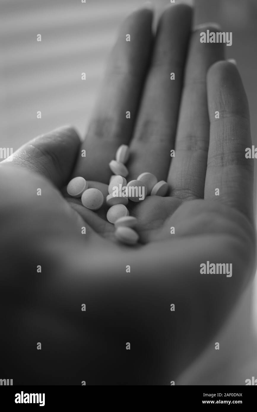 Medizinische Pillen in eine junge weibliche Hand. Schwarz-weiß Foto. Tre Stockfoto