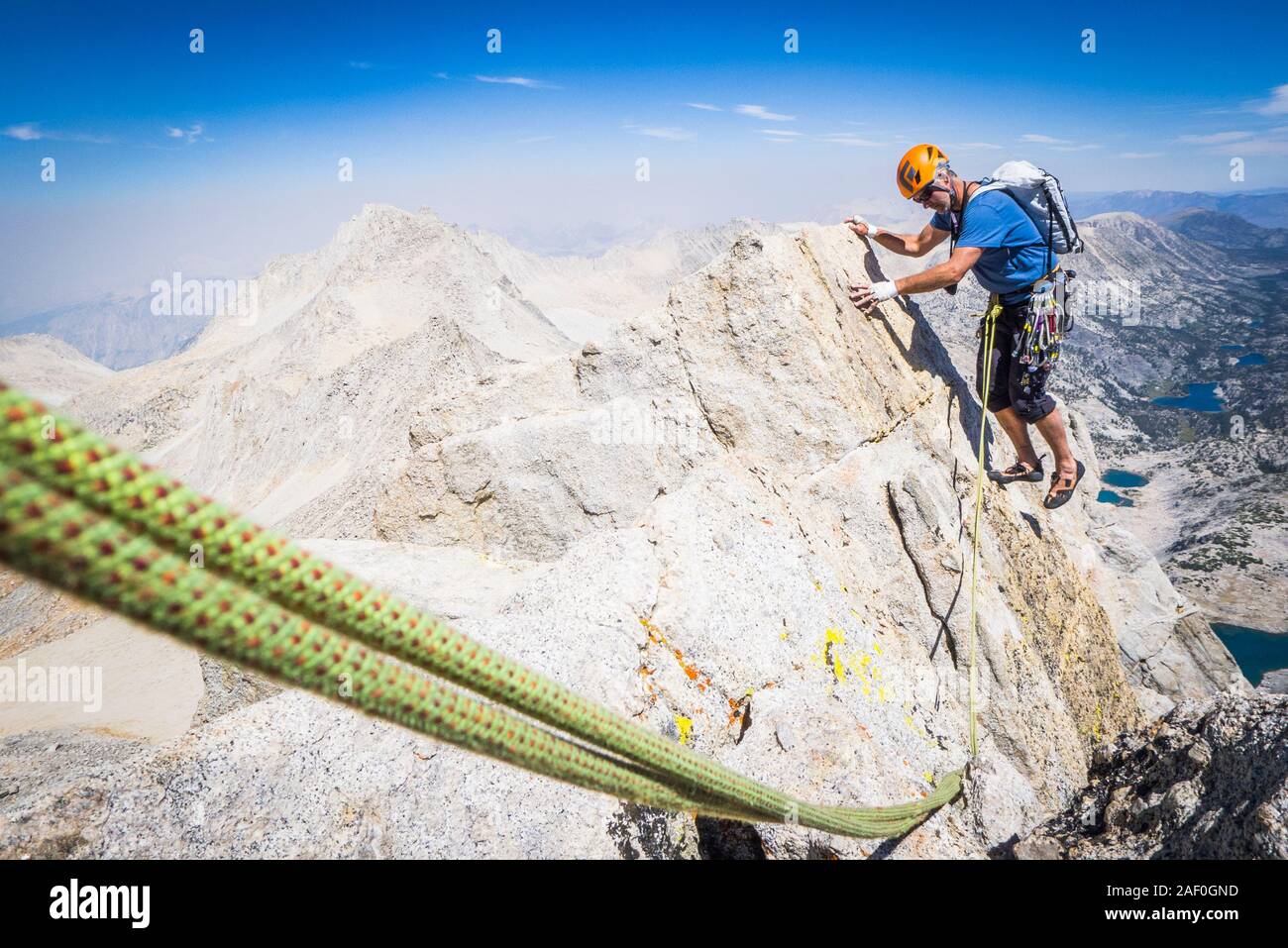 Man Klettern auf hohen ridgeline oben Tal Stockfoto