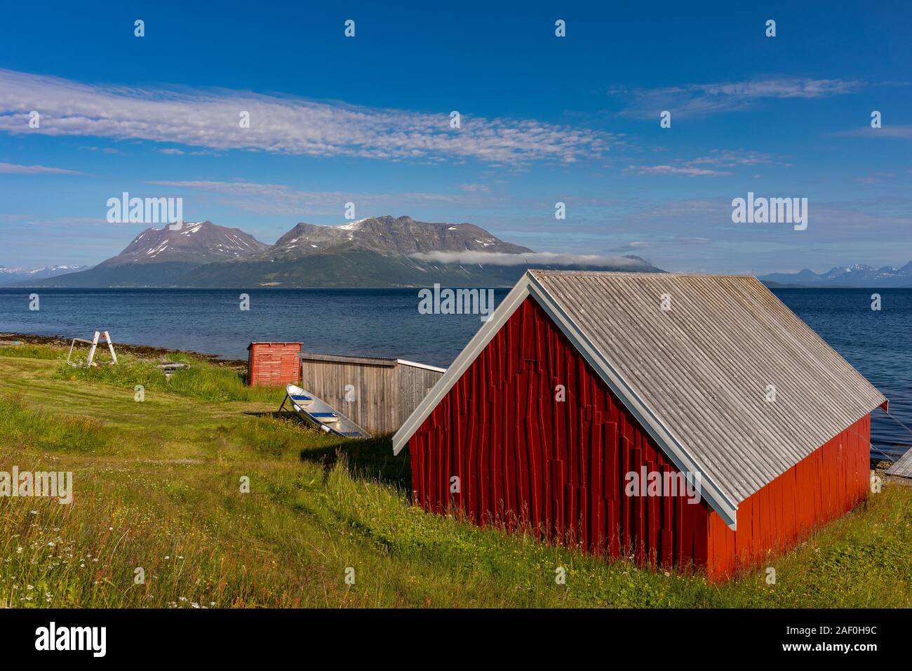 BAKKEJORD, INSEL KVALØYA, Troms, Norwegen - Rote Scheune auf dem Bauernhof von Fjord. Stockfoto