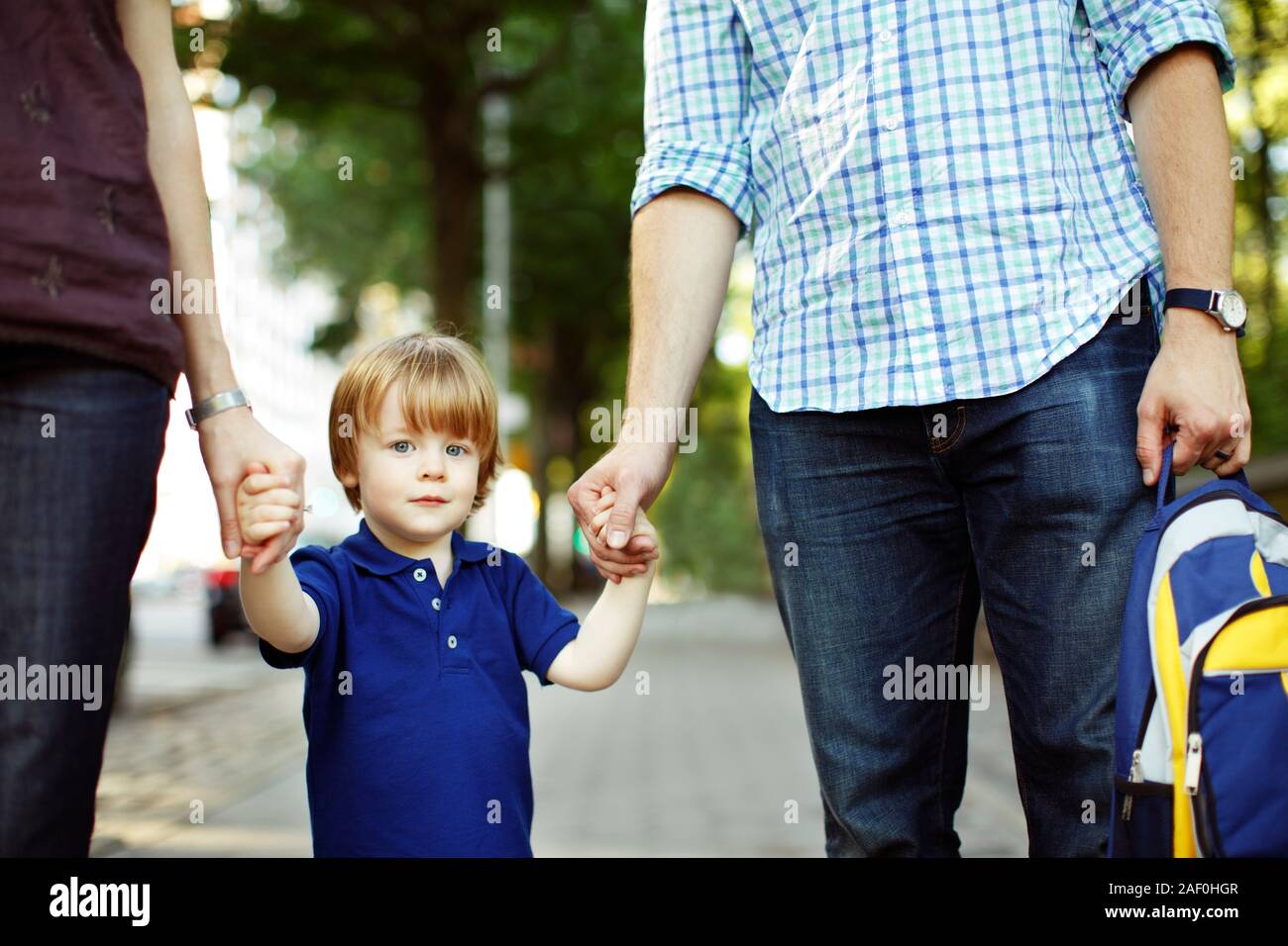 Eltern wandern Sohn zum Kindergarten oder Kindertagesstätte Stockfoto