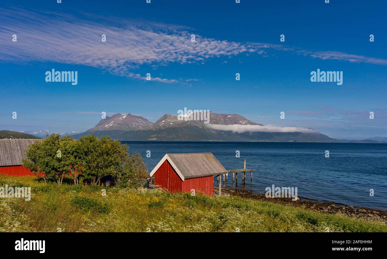 BAKKEJORD, INSEL KVALØYA, Troms, Norwegen - Rote Scheune auf dem Bauernhof von Fjord. Stockfoto