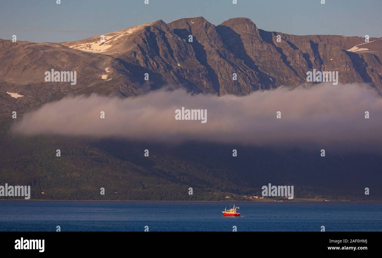TROMS, NORWEGEN - Boot geht über Berge, auf Straumsfjorden Fjord, Nördliche Norwegen. Stockfoto