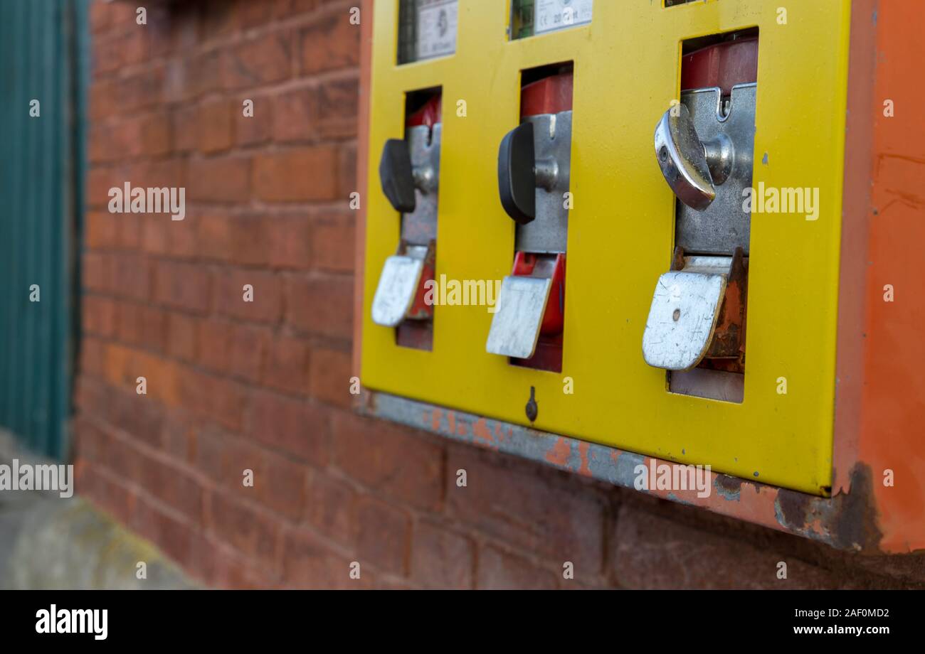 Gelbe Gumball machine an der Wand Stockfoto