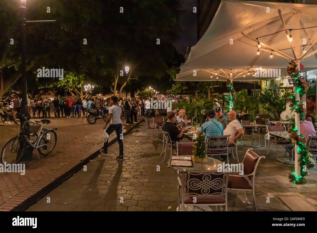 Menschen, die in einem Café in der Nähe eines Parks in der Kolonialzone in der lateinamerikanischen Dominikanischen Republik sitzen. Stockfoto
