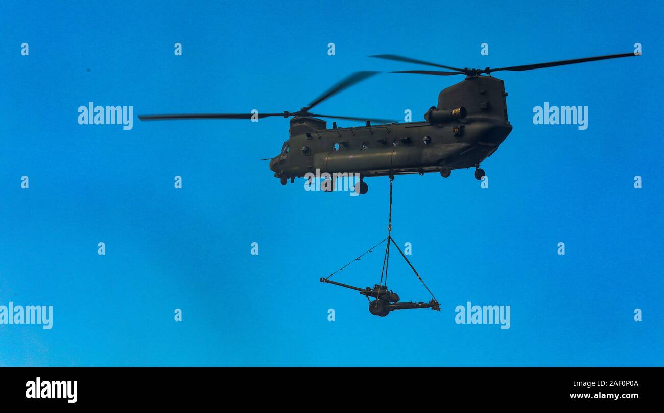 Royal Air Force CH 47 Chinook Hubschrauber mit einem L 118 leichten Artilleriegeschützen underslung Last im Flug Stockfoto