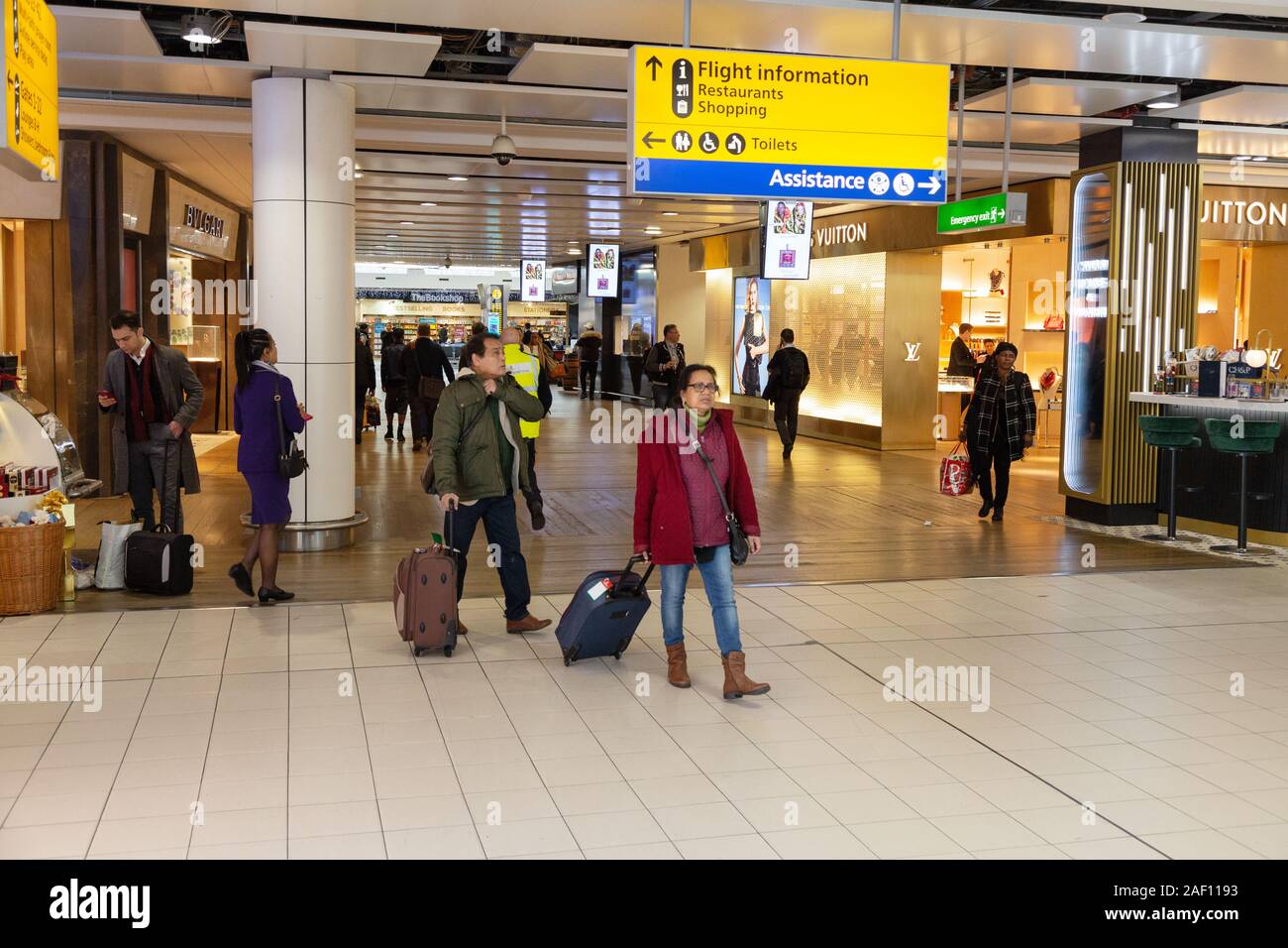 Heathrow T3 Innenraum; Passagiere zu Fuß in den Abflugbereich, Flughafen Heathrow, London, England, Großbritannien Stockfoto