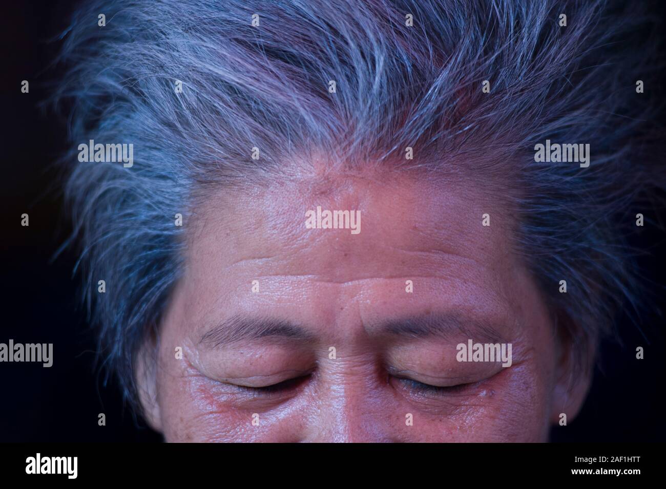 Bangkok, Thailand - 18 April 2011: Konzeptionelle Portrait von älteren Thai Frau mit geschlossenen Augen und graue Haare am Khlong Toei Nachbarschaft, einer armen Gegend o Stockfoto