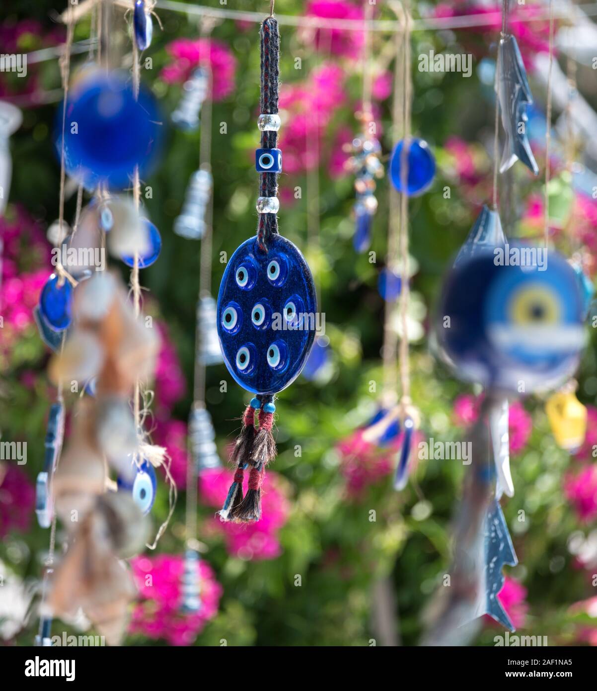 Der böse Blick Charme, trukish Souvenirs hängenden gegen einen Hintergrund von mediterranen Blumen. Türkische Ägäis, Türkei Stockfoto