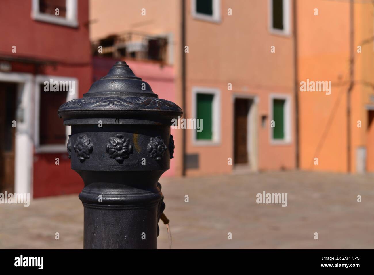 Nahaufnahme eines antiken öffentlichen Wasser in Venedig mit venezianischen Häusern im Hintergrund tippen, Stockfoto
