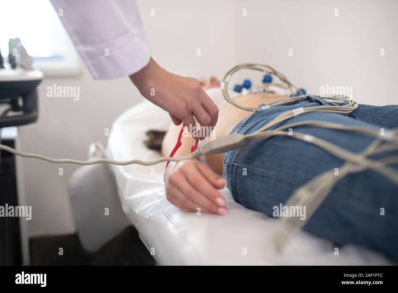 Arzt im weißen Gewand Elektrokardiogramm, die für den Patienten Stockfoto