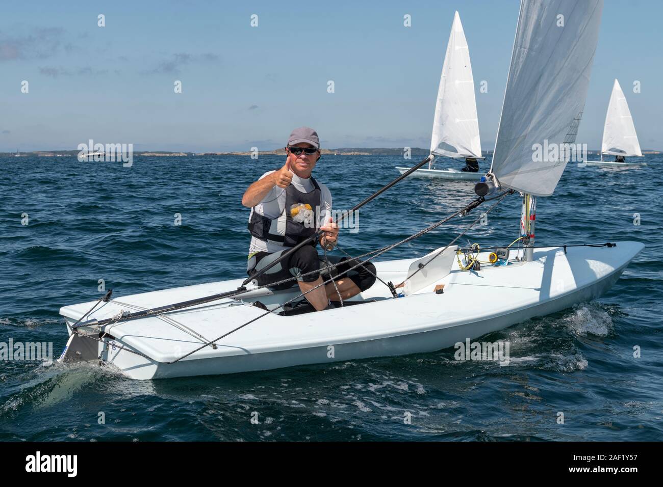 Mann sitzt auf Segelboot Stockfoto
