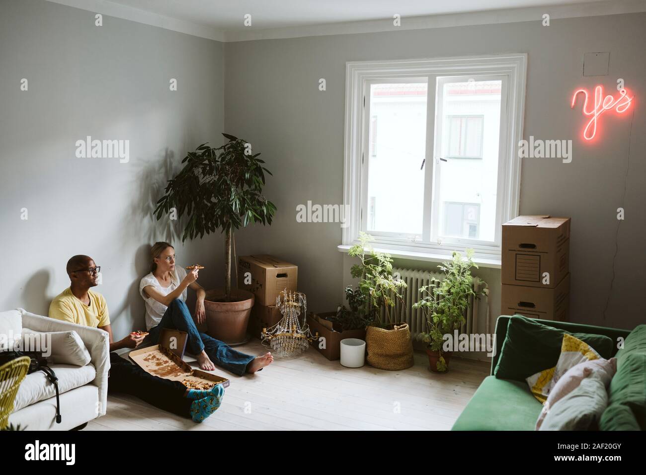 Paar sitzen auf dem Boden und Pizza Stockfoto