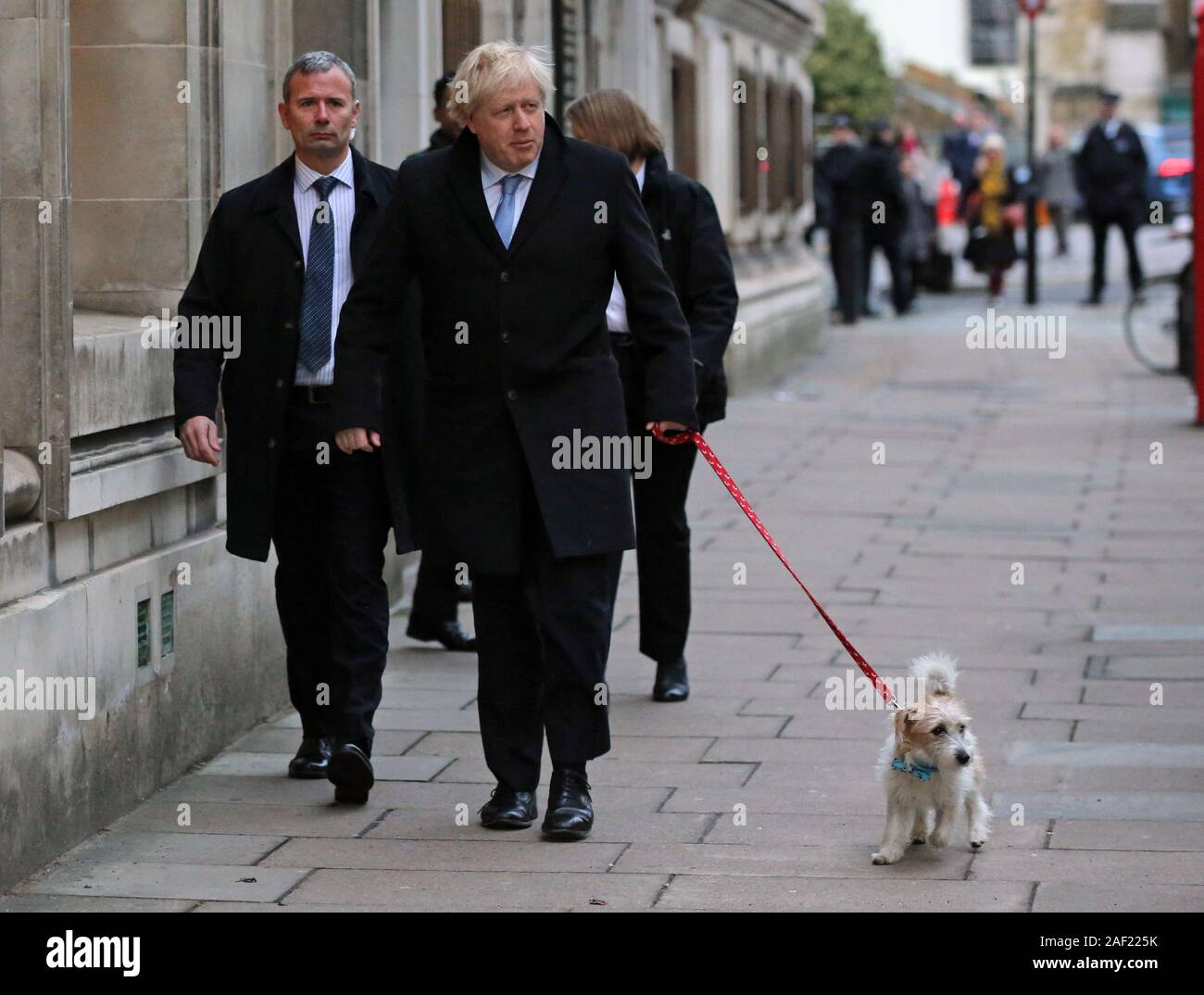 Premierminister Boris Johnson kommt mit seinem Hund Dilyn seine Stimme im 2019 allgemeine Wahlen am methodistischen Central Hall, London zu werfen. Stockfoto