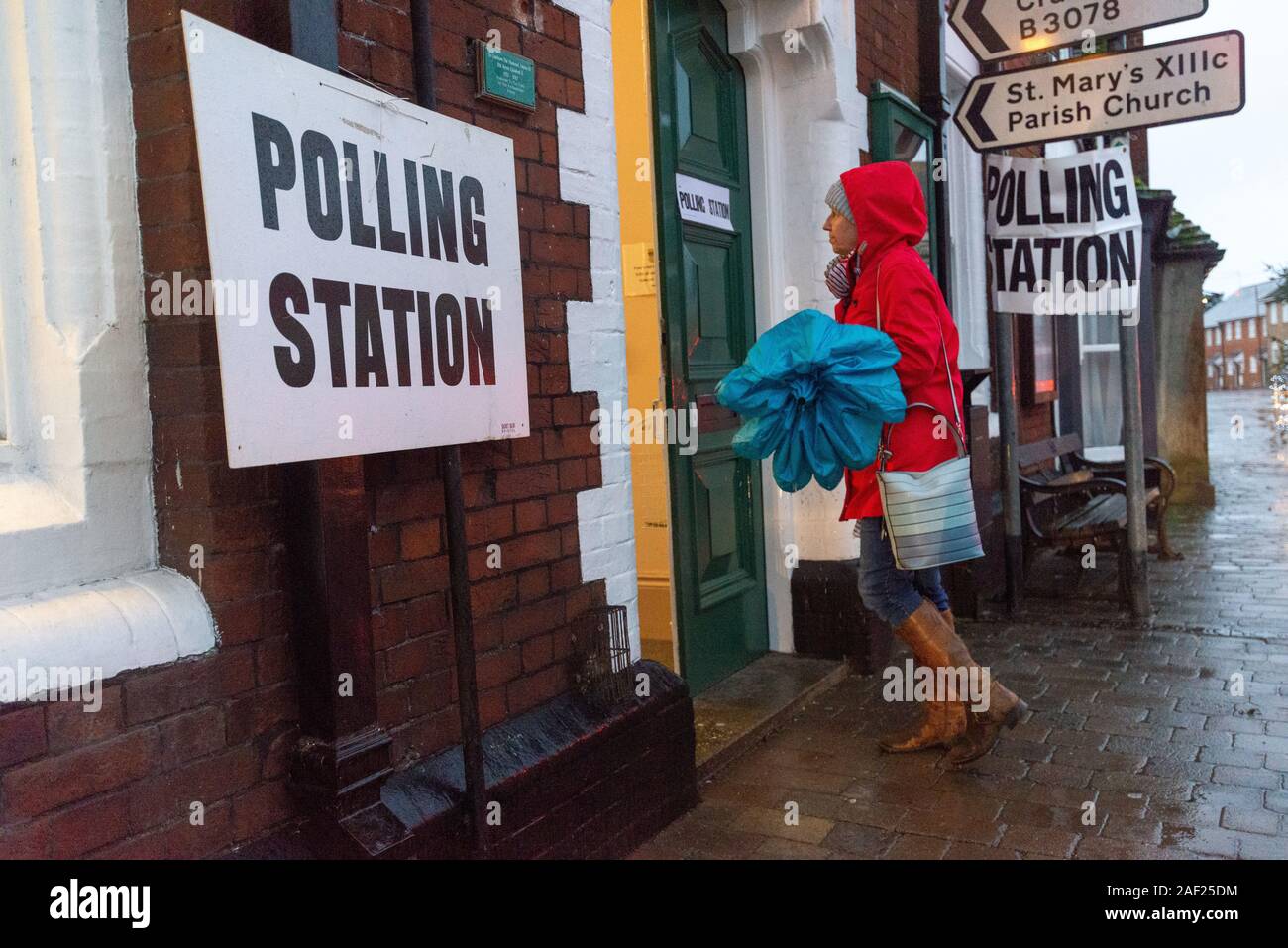 Fordingbridge, Hampshire, England, Vereinigtes Königreich, 12. Dezember 2019. Es ist Zeit, Ihre Farbe zu wählen. Die Abstimmung über die britischen Parlamentswahlen 2019 im Wahlkreis New Forest West ist im Gange. Ein Regenmantel und ein Regenschirm sind erforderlich, da heftiger Regen die Wähler am frühen Morgen am Wahlschalter des Rathauses begrüßt. Der Sitz wird von den Konservativen mit großer Mehrheit gehalten. Stockfoto