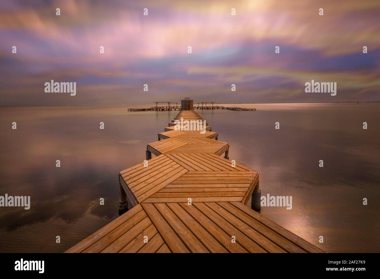 Steg in das Wasser vom Mar Menor bei Santiago de la Ribera (Spanien). Europas groesste Lagune. Auf der gegenueber liegenden Seite ist Sterben La Manga, Langzeitaufnaheme daher sind die Wolken so verzogen. 27.10.18 | Verwendung weltweit Stockfoto