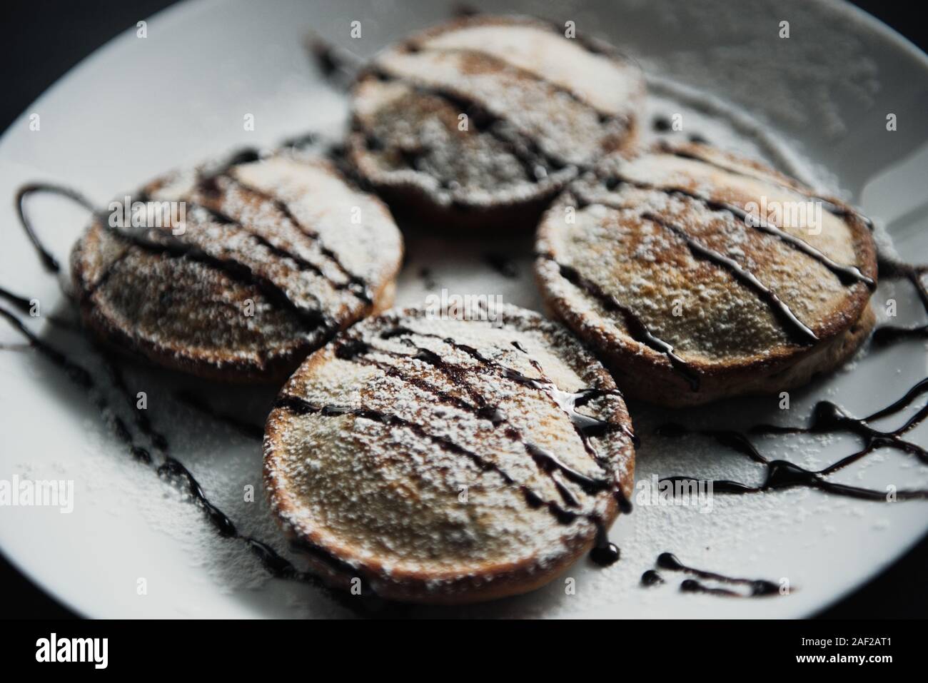 Hausgemachte Schokolade Pfannkuchen serviert auf einem weißen Teller über schwarzen Textur Hintergrund. Schönen Pfannkuchen. Stockfoto