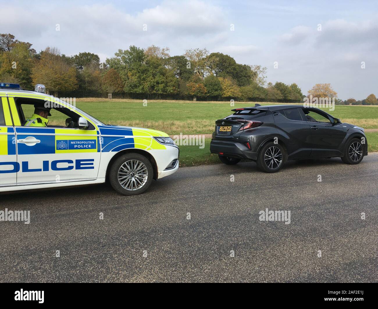 Ein Auto/Autofahrer/Fahrer/Fahrzeug, das von dem Beamten der Metropolitan Polizei/Verkehrspolizisten bei der Erfüllung seiner Aufgaben angehalten wurde. Manchmal werden die Menschen in Royal Parks angehalten, weil sie das Tempolimit von 32 Meilen pro Stunde überschreiten. Richmond Park, London. Großbritannien (Stockmo). Die Fahrzeugnummer wurde auf anonymisierte Fahrer pixeliert. Stockfoto