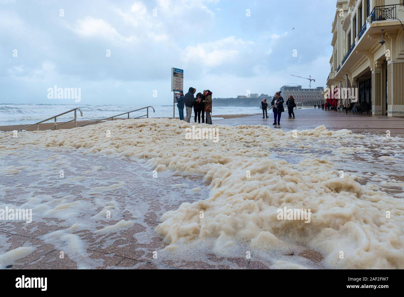 Schaum auf der Grande Plage Strand und seine Quay in Frankreich Stockfoto