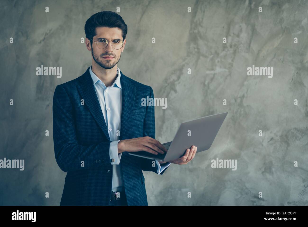 Foto von zuversichtlich ernsthaft nachdenklich nachdenklich Mann an Sie starrte angestrengt Holding computer mit Händen mit Borsten auf Gesicht isolierte graue Farbe Stockfoto