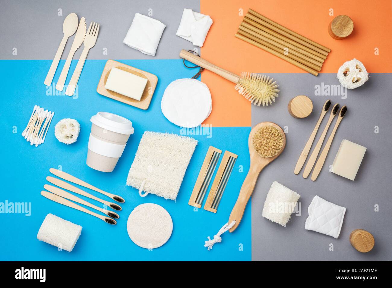 Null Abfall umweltfreundliche Personal Care Produkte bambus holz- Bürsten, Zahnbürsten, luffa, Naturseifen, wiederverwendbare Kaffeetasse auf bunten Blau Grau orange Hintergrund, selektiver Fokus Stockfoto