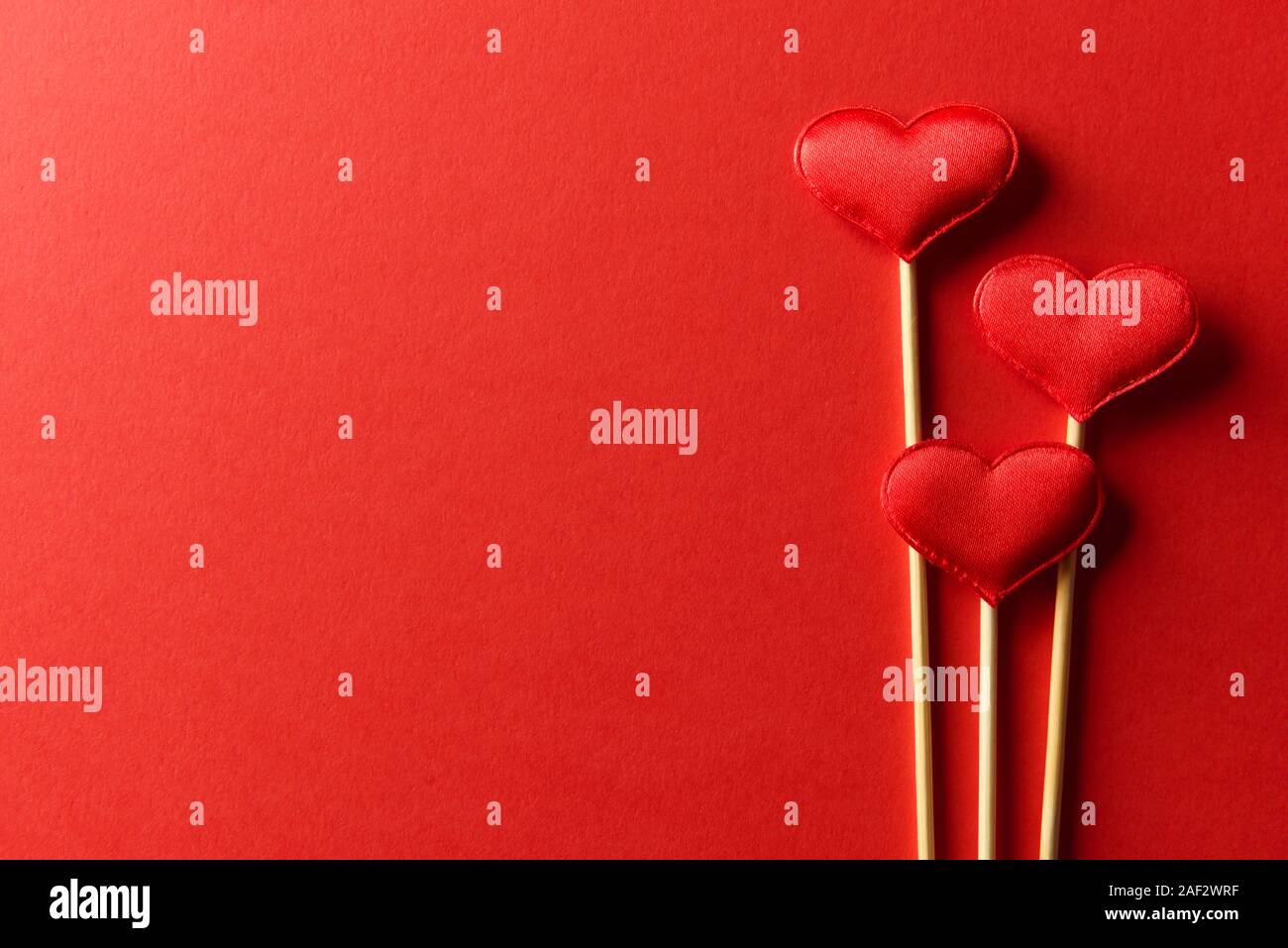 Red textile Herzen auf Holzstäbchen Nahaufnahme. Valentines Tag Hintergrund, kreative Textur und liebe Konzept Stockfoto