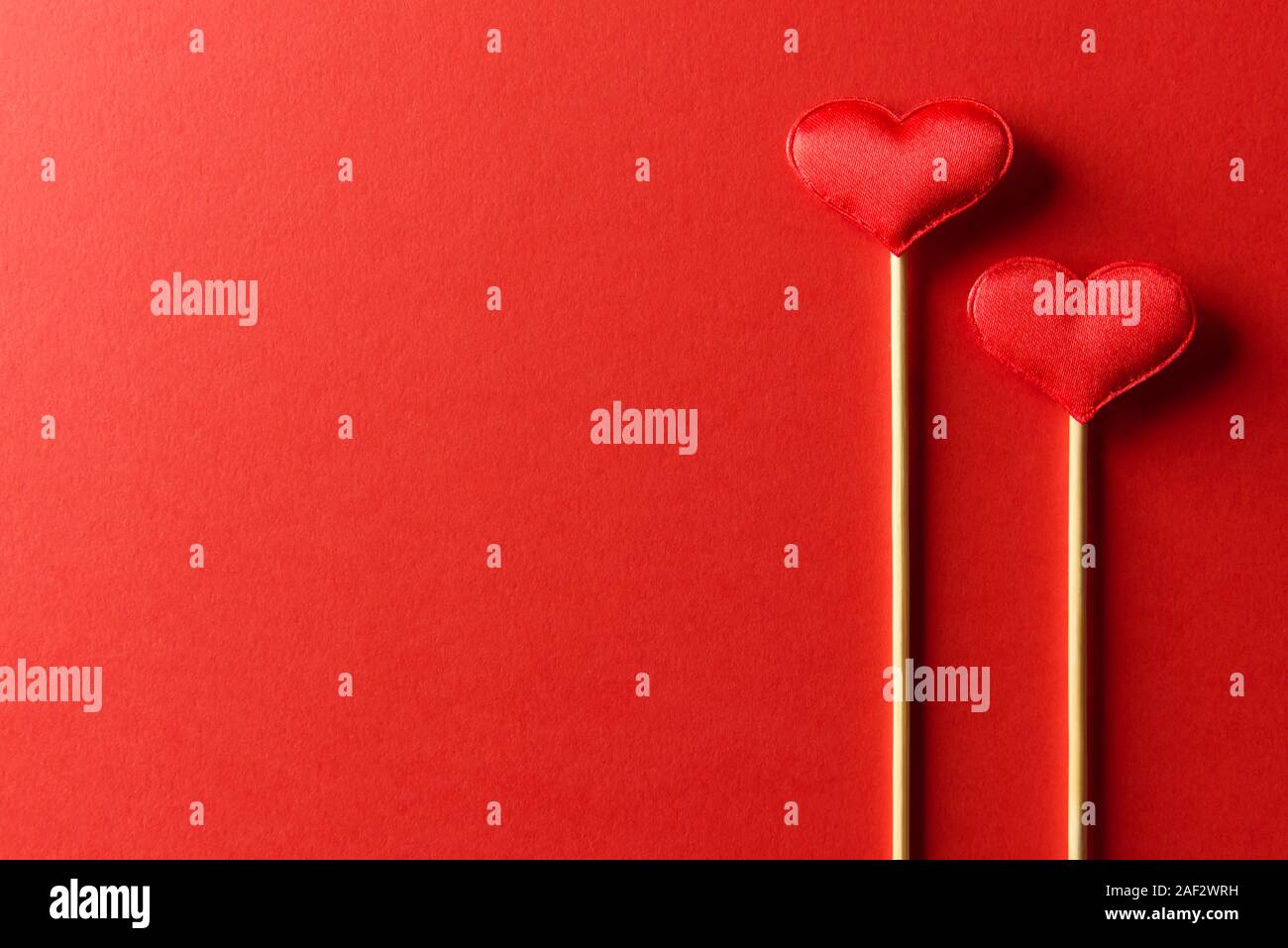 Red textile Herzen auf Holzstäbchen Nahaufnahme. Valentines Tag Hintergrund, kreative Textur und liebe Konzept Stockfoto