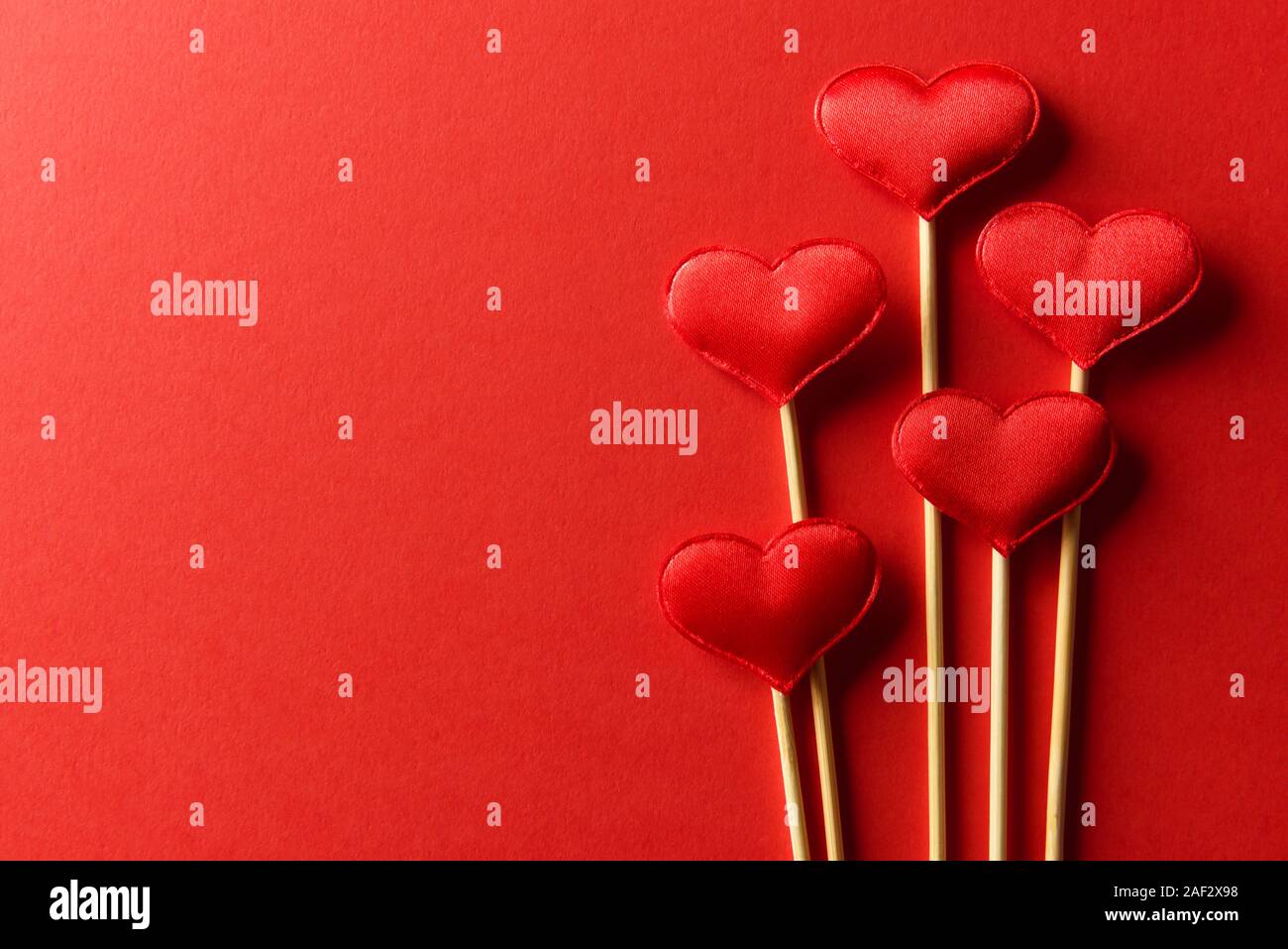 Red textile Herzen auf Holzstäbchen Nahaufnahme. Valentines Tag Hintergrund, kreative Textur und liebe Konzept Stockfoto