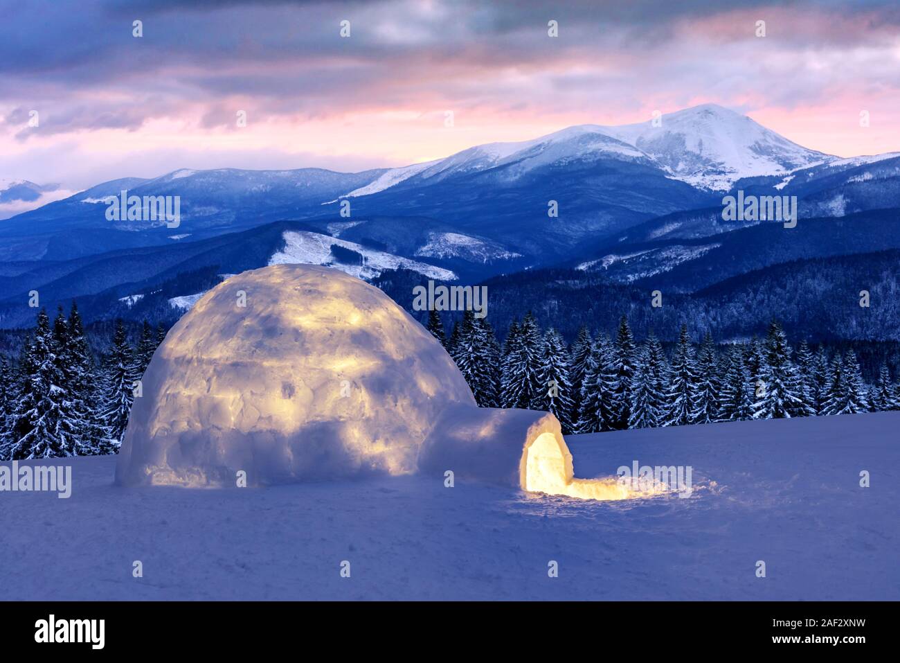 Echten schneeiglu Haus im Winter Berge. Verschneite Tannen und Gipfeln im Hintergrund. Nebligen Wald mit schneebedeckten Fichten Stockfoto