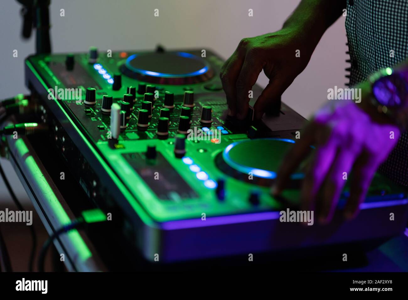 Club-DJ spielt Musik auf der Bühne im Nachtclub. Hand der disc jockey Sound Track Lautstärke einstellen. Professionelle Audiogeräte auf Music Festival Stockfoto