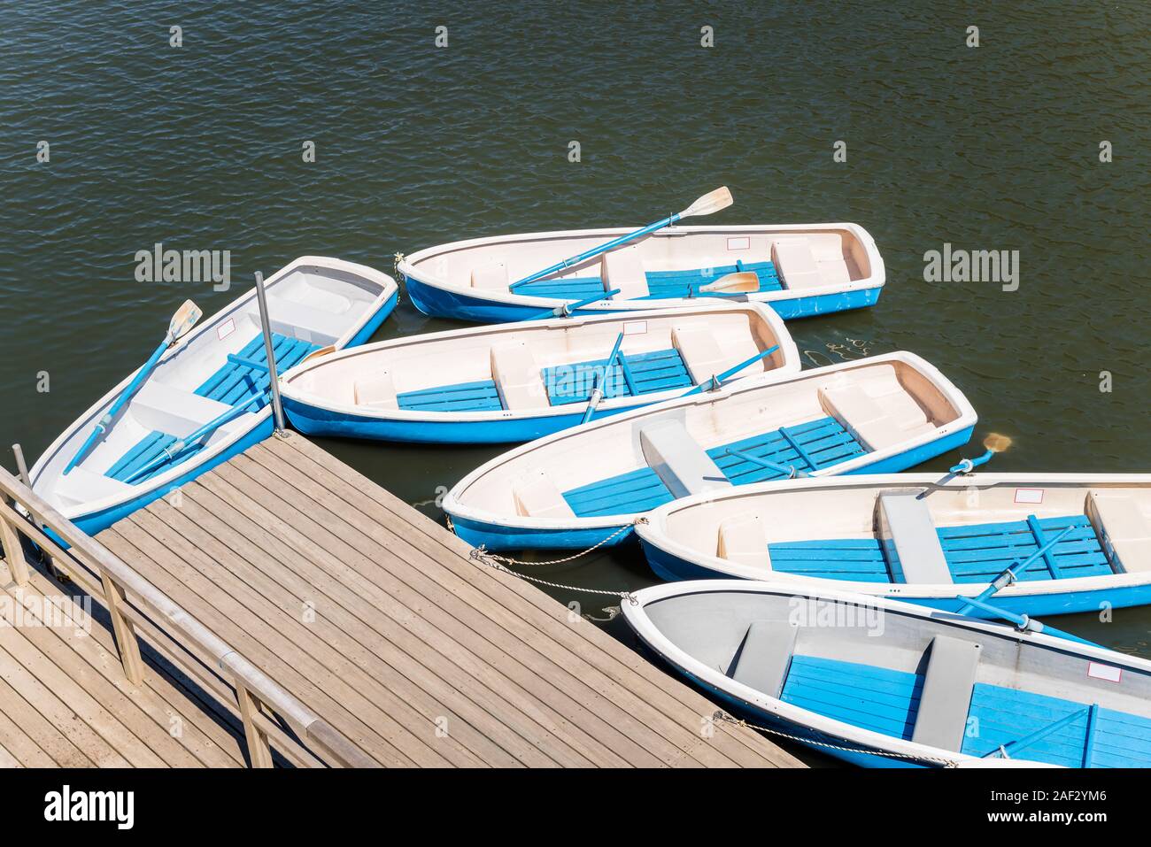 Freizeitaktivitäten Ruderboote gebunden bis zu einem Holzsteg in einem Park an einem sonnigen Tag Stockfoto