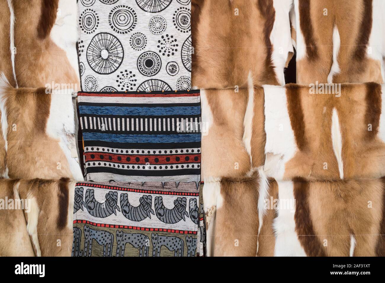 Springbock Antilope tierischer Haut oder zusammen mit afrikanischen Muster Gewebe auflegen auf Anzeige zum Verkauf an ein Tourist shop in Südafrika ausblenden Stockfoto
