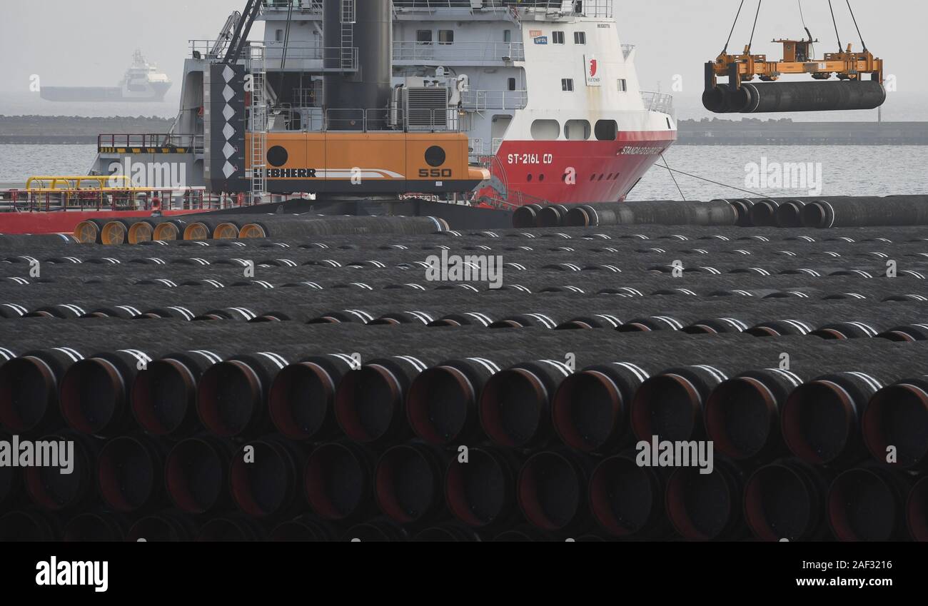 12 Dezember 2019, Mecklenburg-Vorpommern, Sassnitz: Rohre für die Nord Stream 2 Ostseepipeline wird auf ein Schiff im Hafen Mukran geladen werden. Das US-Repräsentantenhaus hat Sanktionen gegen Unternehmen, die in Verbindung mit der Nord Stream 2 Ostseepipeline gestartet. Foto: Stefan Sauer/dpa-Zentralbild/dpa Stockfoto