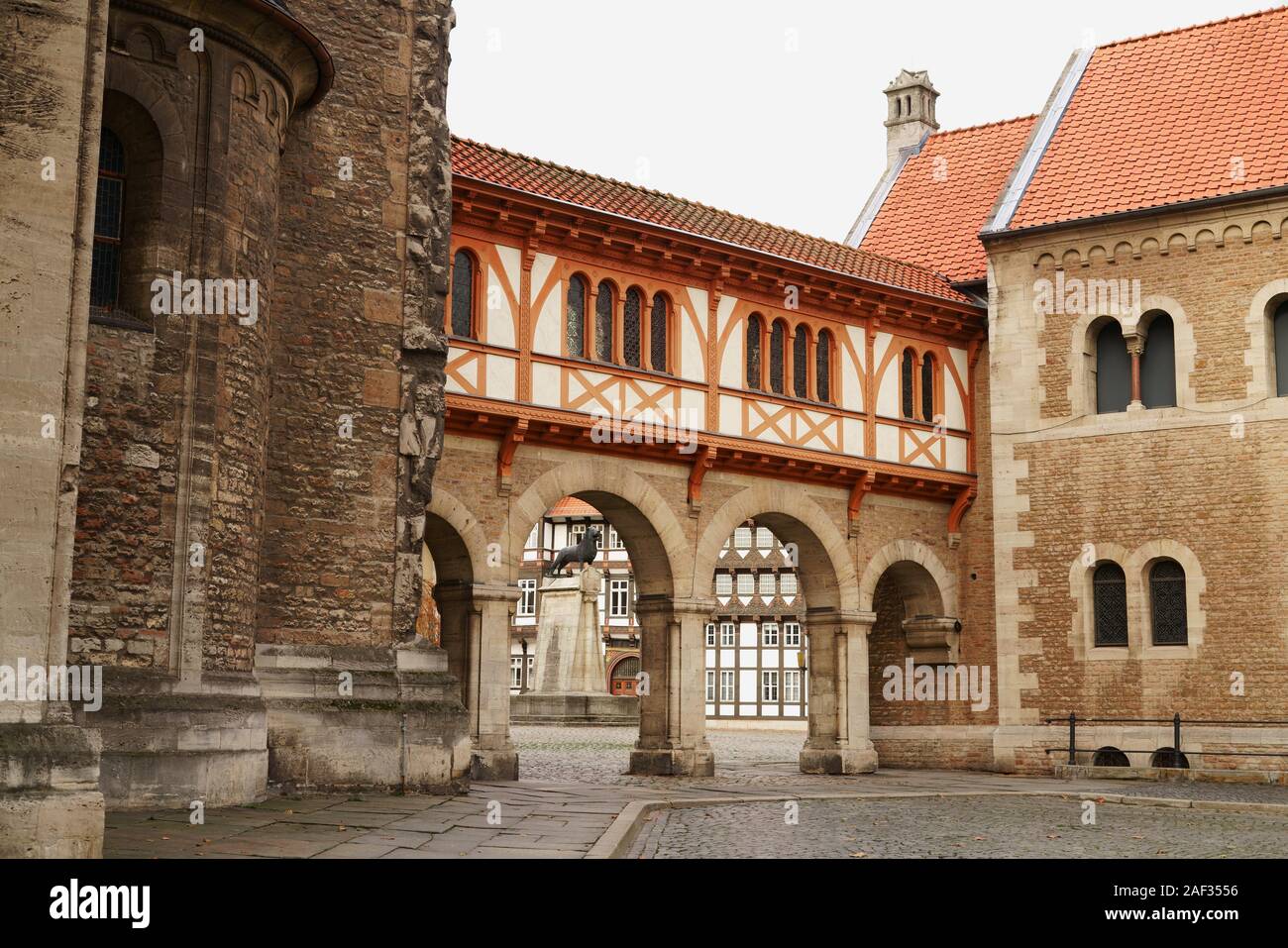 Historische Altstadt von Braunschweig, Niedersachsen in Deutschland. Schlossplatz durch die Torbögen der Burg und Braunschweiger Löwe Statue gesehen. Stockfoto