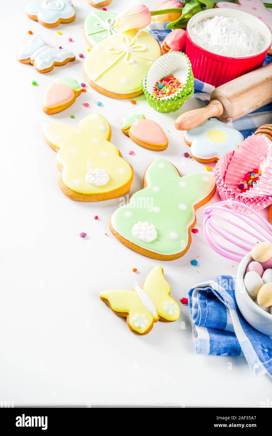 Süße Ostern backen kochen Hintergrund mit traditionellen Osterhase und Ei cookies, Zucker besprüht, Zutaten und Utensilien. Weißem Hintergrund c Stockfoto
