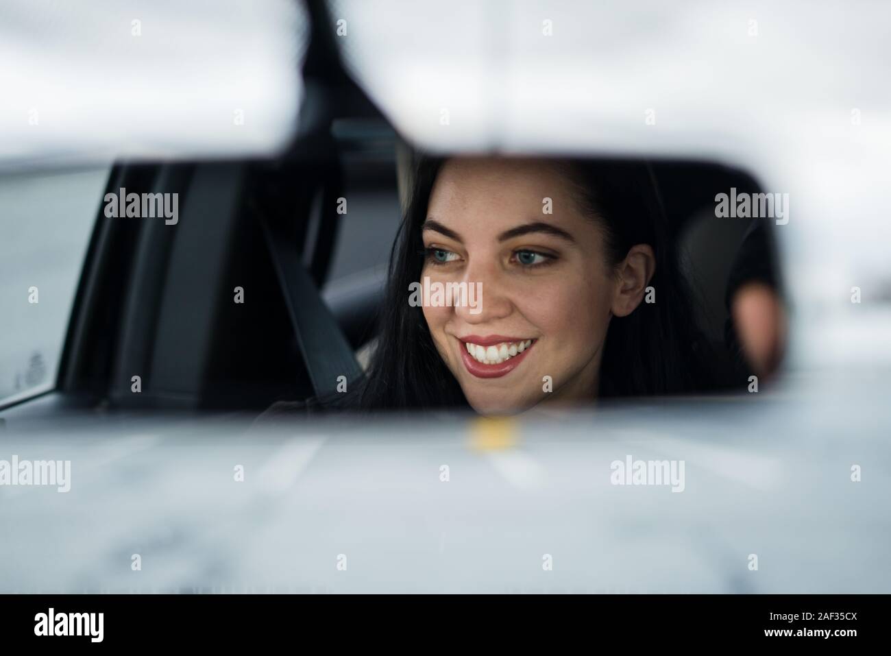 Schöne junge Frau Auto POV von Rückspiegel Stockfoto