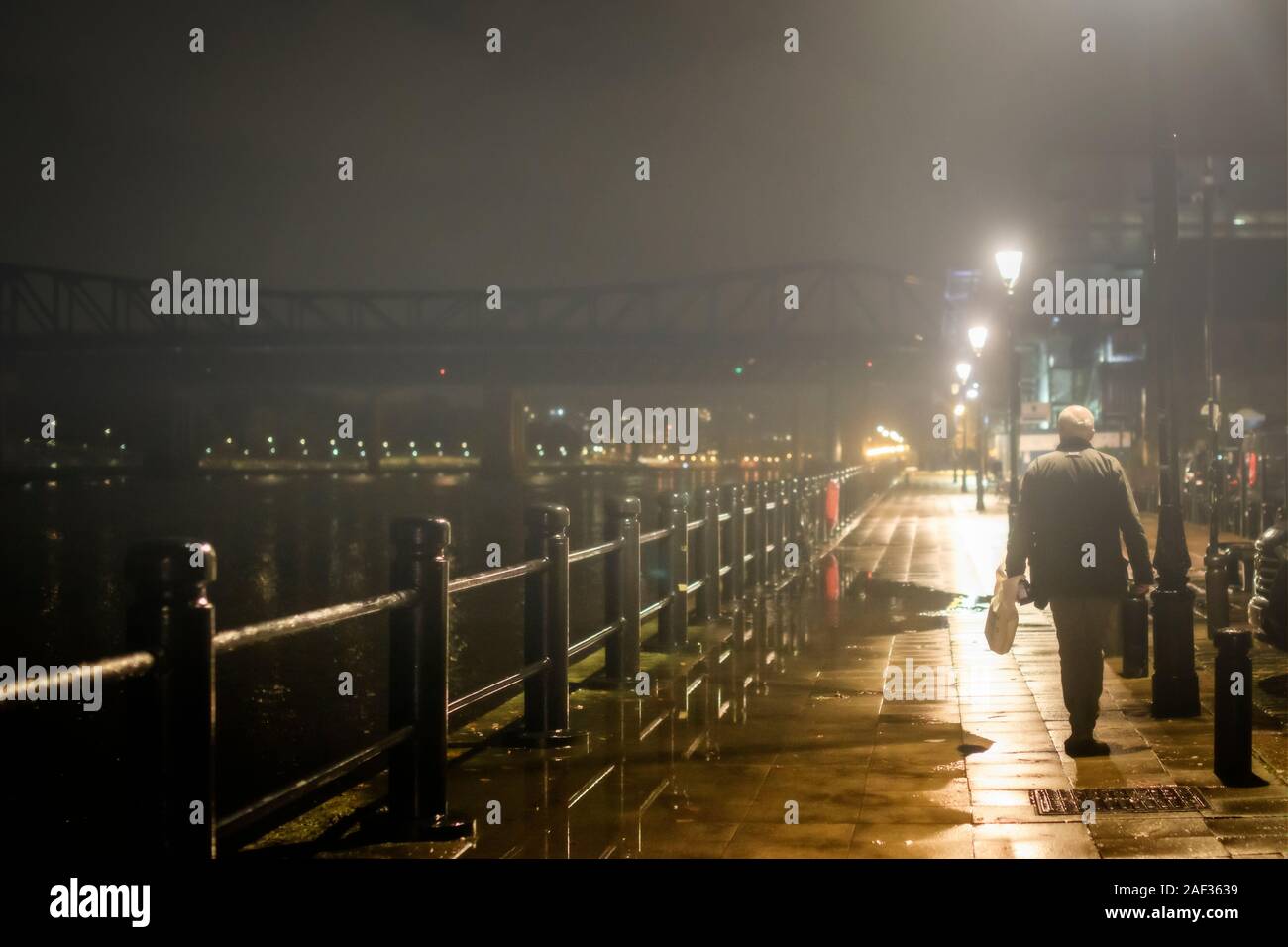 Einsame mann Spaziergänge entlang nebliger Kai von Newcastle-upon-Tyne Stockfoto