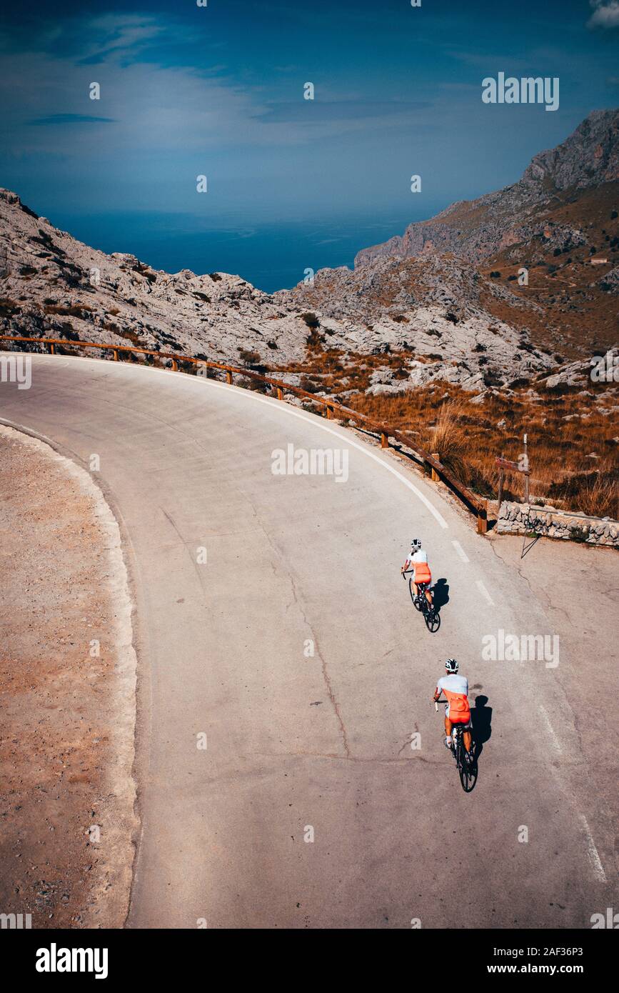 Paar Fahrt zusammen auf der Straße Fahrrad in die Berge. Meer im Hintergrund. Mallorca, Spanien Stockfoto
