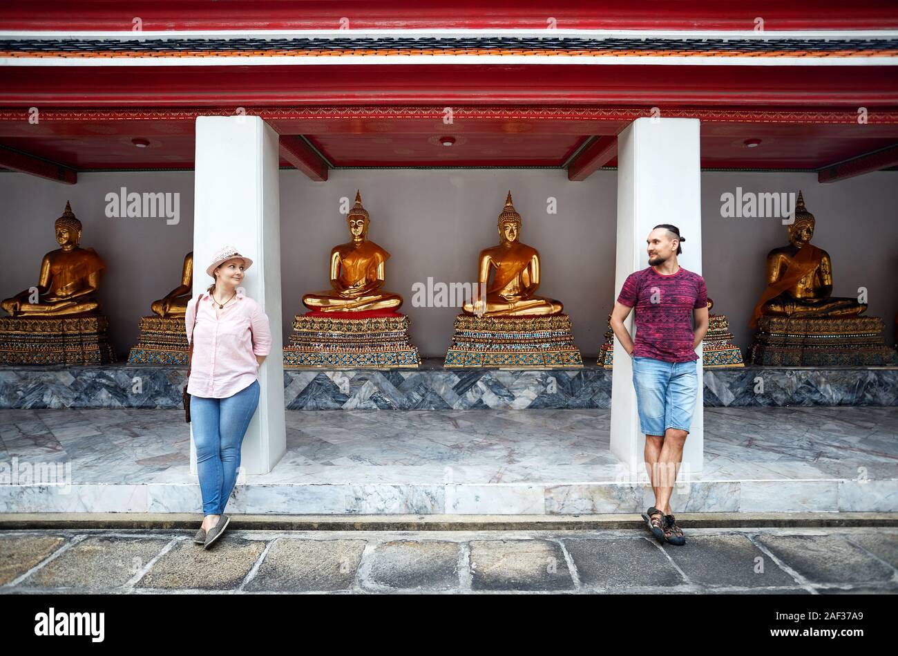Junge Familie Paar steht in der Nähe von Buddha Statuen von Wat Pho Tempel in Bangkok, Thailand Stockfoto