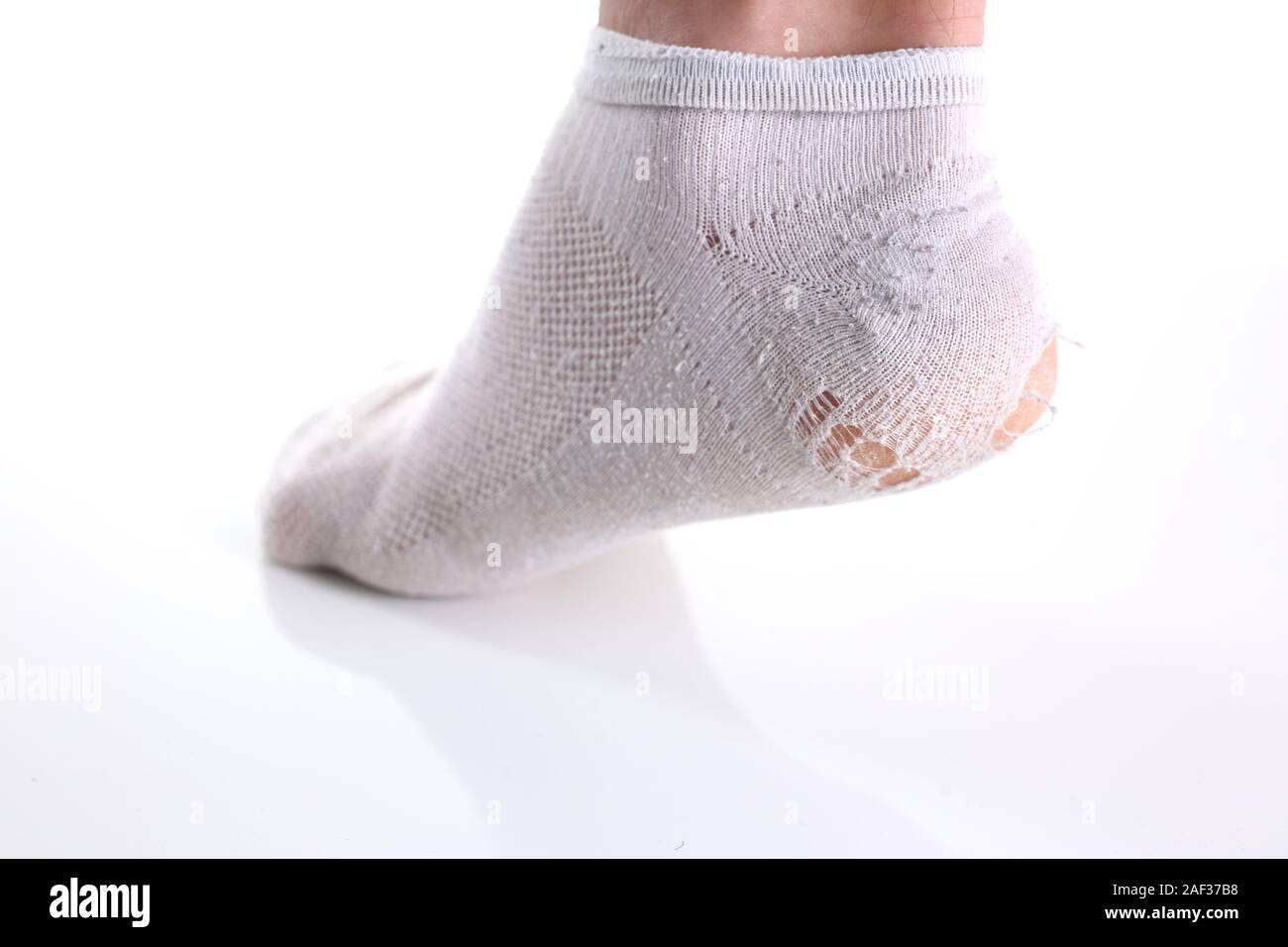 Rip-weiße Socken auf männliches Bein isoliert Stockfoto