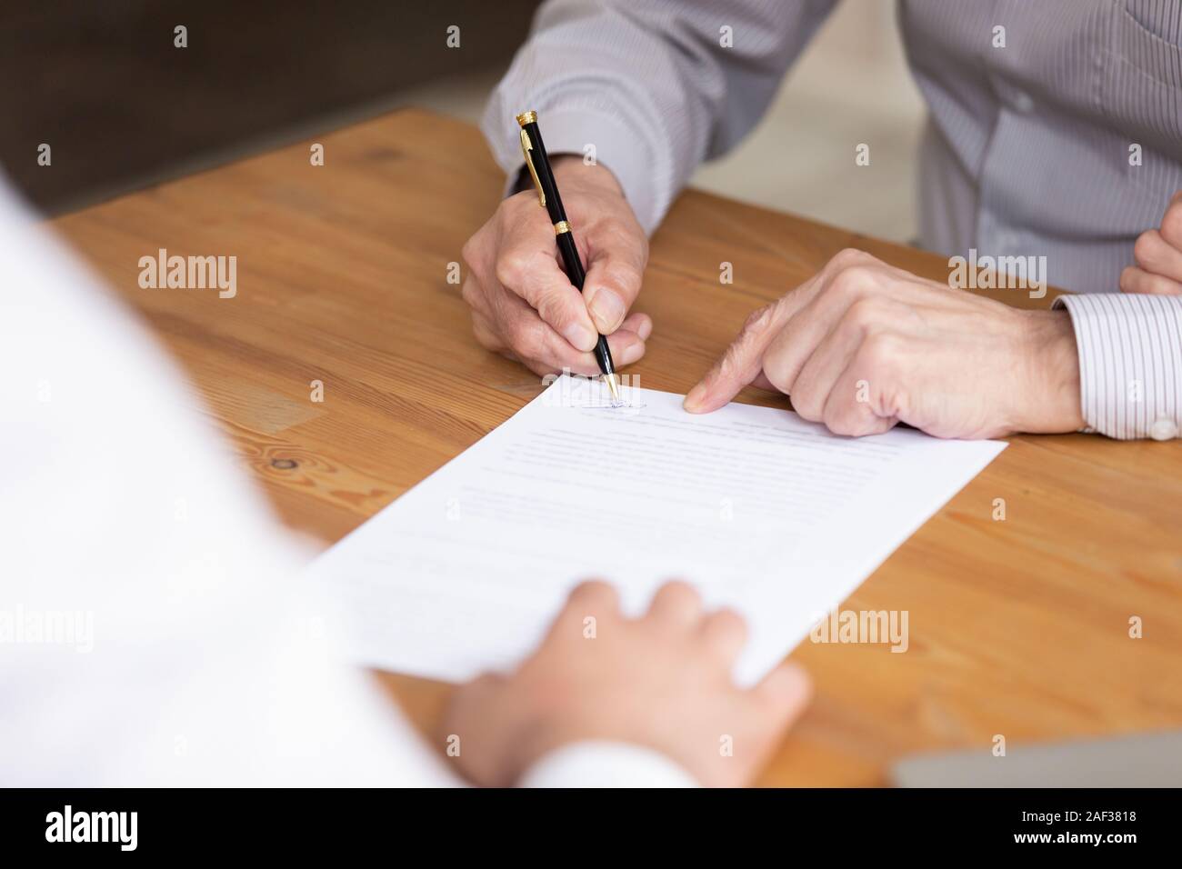 Ältere männliche Hand Unterzeichnung Dokument schließen Sie herauf Bild Stockfoto