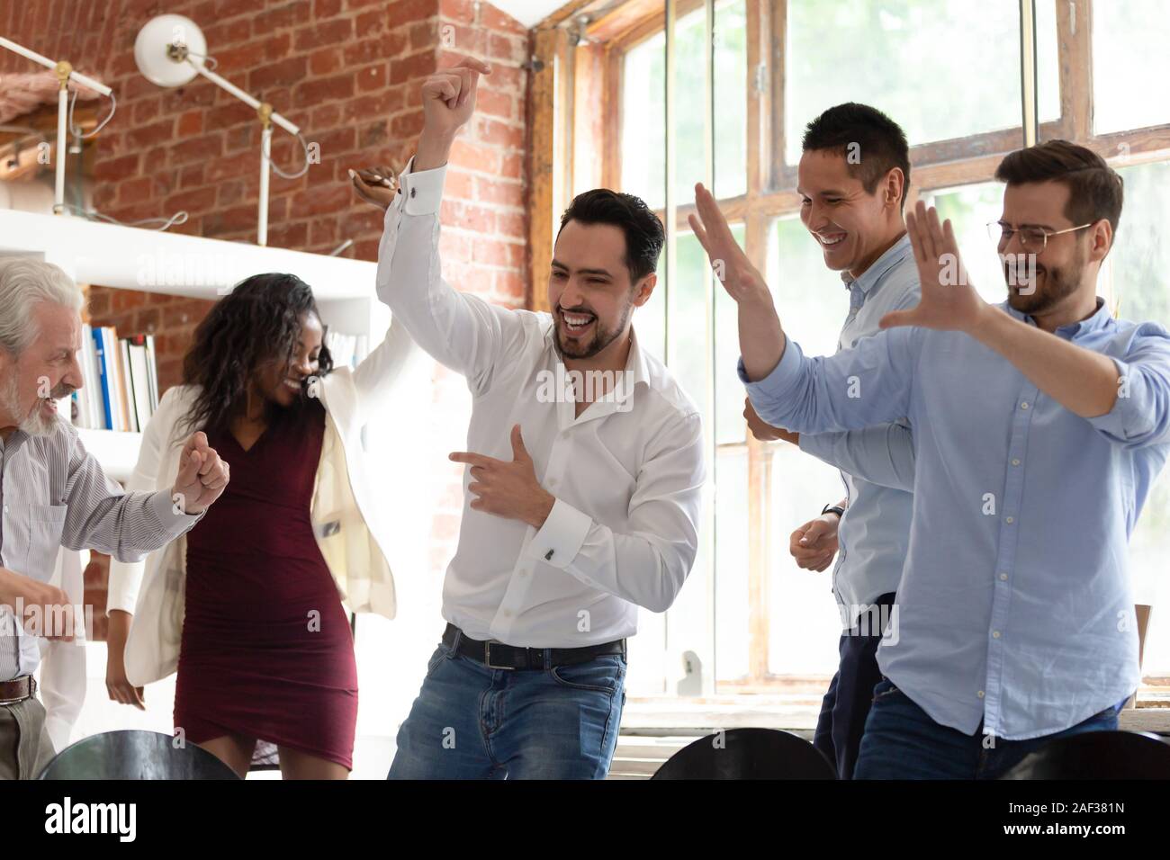 Multirassischen Kollegen Tanz Corporate Partei oder feiern erfolgreichen Abschluss Stockfoto
