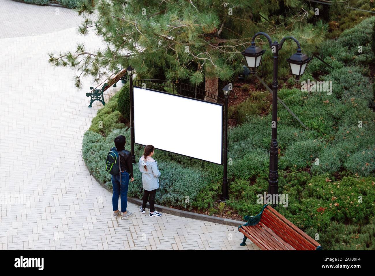Zwei Menschen betrachten ein Zeichen im Park. Stockfoto